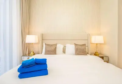 a bedroom with a white bed with two blue bags on it at NewArabian Forte Downtown in Dubai