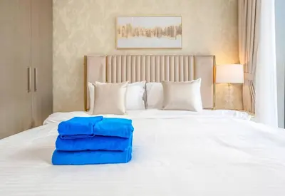 a white bed with two blue pillows on it at NewArabian Forte Downtown in Dubai