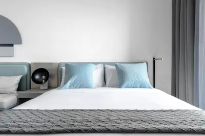 a bedroom with a large bed with blue pillows at Modern Meydan Studio Apartment - 15 min Drive to Downtown Dubai Mall in Dubai