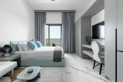 a bedroom with a king sized bed and a living room at Modern Meydan Studio Apartment - 15 min Drive to Downtown Dubai Mall in Dubai