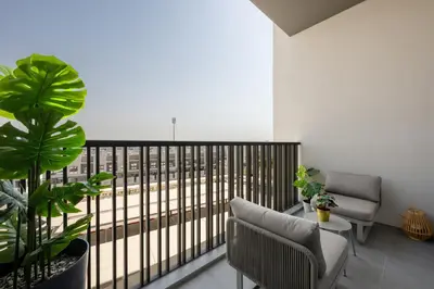 a balcony with two chairs and a table at Modern Meydan Studio Apartment - 15 min Drive to Downtown Dubai Mall in Dubai