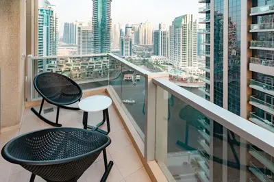 a balcony with two chairs and a view of a city at Prime Retreats - steps to Grosvenor Hotel Marina in Dubai