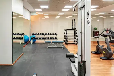 a gym with treadmills and machines in it at Prime Retreats - steps to Grosvenor Hotel Marina in Dubai