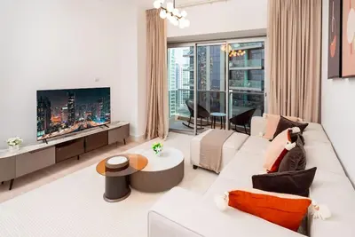 a living room with a white couch and a large window at Prime Retreats - steps to Grosvenor Hotel Marina in Dubai