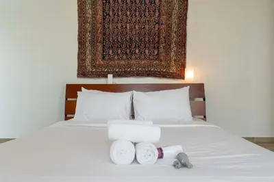 a bed with two rolls of towels on it at StayShort - Cozy 1-Bedroom Haven in Business Bay in Dubai