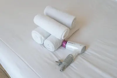 a hair dryer and towels on a bed at StayShort - Cozy 1-Bedroom Haven in Business Bay in Dubai