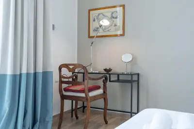 a desk with a chair and a lamp next to a bed at StayShort - Cozy 1-Bedroom Haven in Business Bay in Dubai