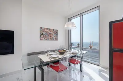 a dining room with a table and chairs and a large window at StayShort - Cozy 1-Bedroom Haven in Business Bay in Dubai