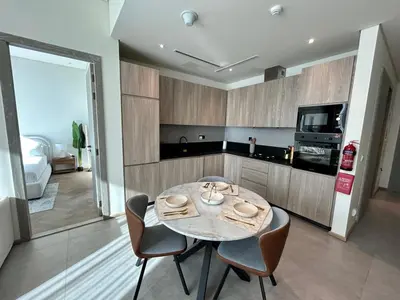 a dining room with a table and chairs in a kitchen at Premium 1BHK Apt In Signature living, JVC! Pool view in Dubai