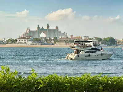 a boat in the water with a city in the background at Atlantis View 1BR with Beachfront Access and Balcony in Dubai