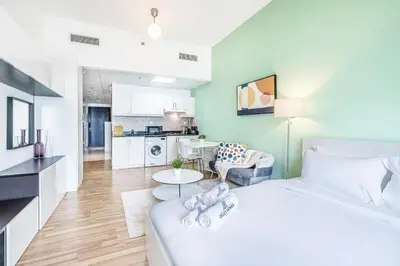 a bedroom with a bed and a living room at Luxe Studio with Upgraded Interior in Sports City in Dubai