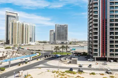 a city with tall buildings and a street with cars at Luxe Studio with Upgraded Interior in Sports City in Dubai