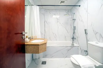 a bathroom with a sink and a tub and a toilet at Moderne 1BR with a lovely marina view in Dubai