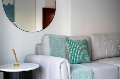 a living room with a couch and a round mirror at Moderne 1BR with a lovely marina view in Dubai