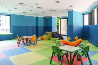 a childrens play room with tables and chairs at Moderne 1BR with a lovely marina view in Dubai