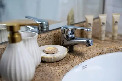 a bathroom counter with a sink with a soap dispenser at Moderne 1BR with a lovely marina view in Dubai