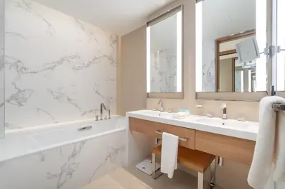 a bathroom with a sink and a tub and a mirror at Spacious 3 Bedroom Apartment in Downtown with Burj Khalifa view in Dubai
