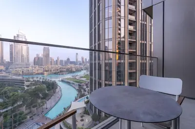 a balcony with a table and a view of a river at Spacious 3 Bedroom Apartment in Downtown with Burj Khalifa view in Dubai
