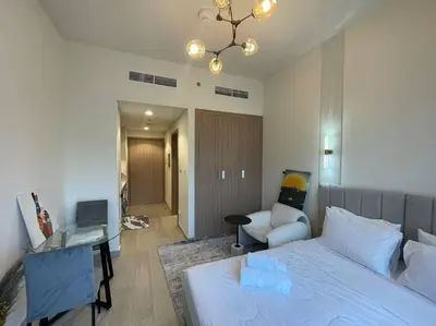 a bedroom with a bed and a desk and a chair at Studio in Azizi Riviera 47 in Dubai