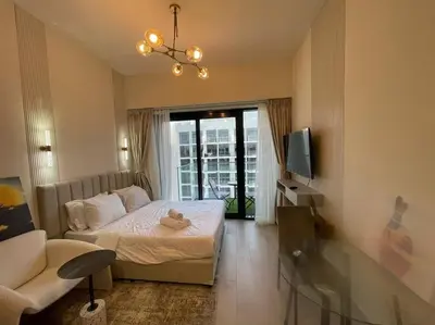 a bedroom with a bed and a couch and a tv at Studio in Azizi Riviera 47 in Dubai