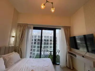 a bedroom with a bed and a tv and a window at Studio in Azizi Riviera 47 in Dubai