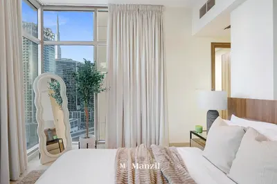 a bedroom with a bed and a large window at Lux 2BR Apartment Near Dubai Mall & Burj Khalifa in Dubai