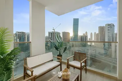 a balcony with two chairs and a view of the city at Lux 2BR Apartment Near Dubai Mall & Burj Khalifa in Dubai