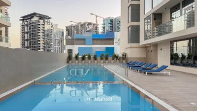 a swimming pool with blue chairs in a building at Lux 2BR Apartment Near Dubai Mall & Burj Khalifa in Dubai