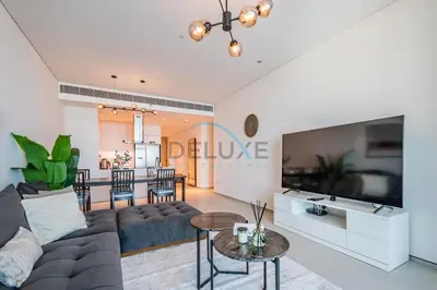 a living room with a couch and a tv at Grand 3BR Aparment at The Address Residences in JBR by Deluxe Holiday Homes in Dubai