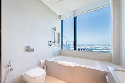 a bathroom with a tub and a toilet and a window at Grand 3BR Aparment at The Address Residences in JBR by Deluxe Holiday Homes in Dubai