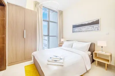 a bedroom with a white bed and a window at Elegant Home next to Metro Station in Al Furjan in Dubai