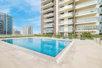 a swimming pool in front of a building at Elegant Home next to Metro Station in Al Furjan in Dubai