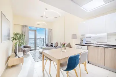 a kitchen and living room with a table and chairs at Elegant Home next to Metro Station in Al Furjan in Dubai