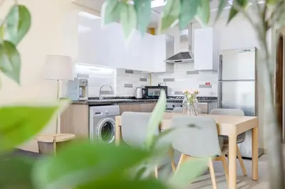 a kitchen with a table and chairs and a washer at Elegant Home next to Metro Station in Al Furjan in Dubai