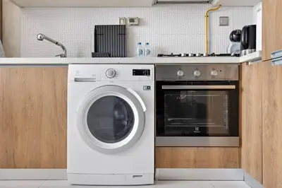 a kitchen with a washing machine and a sink at Modern Studio Close To Metro in Dubai