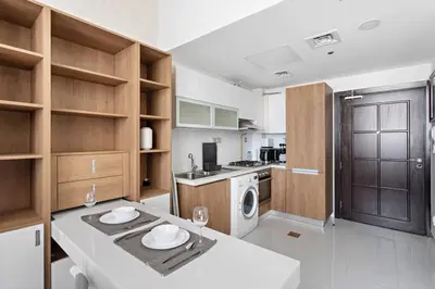 a kitchen with a table with two plates on it at Modern Studio Close To Metro in Dubai