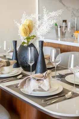 a table set with plates and vases and glasses at Frank Porter - The Address Opera Residences in Dubai
