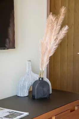 a table with two vases and feathers on it at Frank Porter - The Address Opera Residences in Dubai