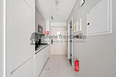 a hallway of a kitchen with a red fire hydrant at Luxury Studio Near To Metro in Dubai