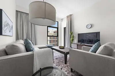 a living room with two couches and a tv at Modern 1 Br Near To Park in Dubai
