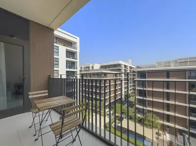 a balcony with two tables and chairs and buildings at Modern 1 Br Near To Park in Dubai