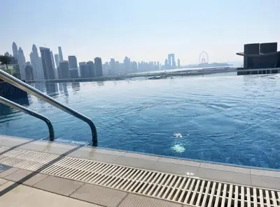 a swimming pool with a city skyline in the background at Seven Palm Hotel with West beach access in Dubai