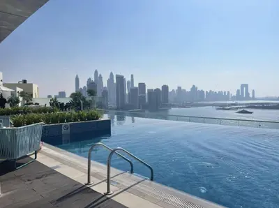 a swimming pool with a city skyline in the background at Seven Palm Hotel with West beach access in Dubai