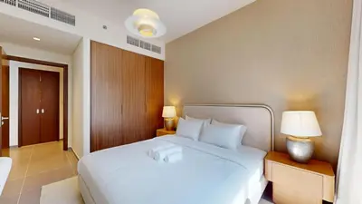 a bedroom with a large white bed and two lamps at Creek Edge - Elegant One Bedroom in Creek Habour in Dubai