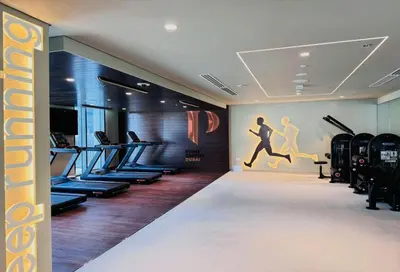 a gym with treadmills and exercise equipment in a room at Creek Edge - Elegant One Bedroom in Creek Habour in Dubai