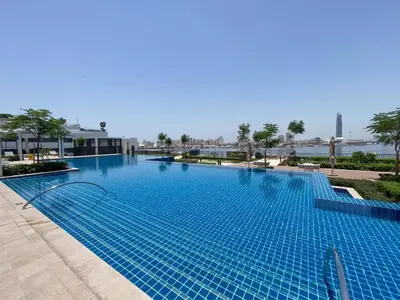 a large blue swimming pool in a building at Creek Edge - One Bedroom with Partial Sea View in Dubai