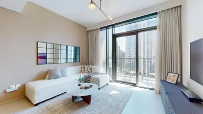 a living room with a white couch and a large window at Creek Edge - One Bedroom with Partial Sea View in Dubai