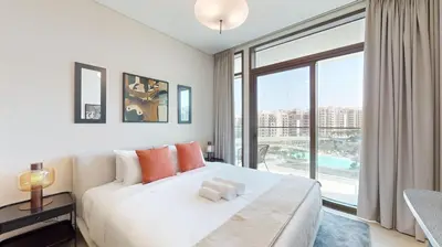 a bedroom with a large bed and a large window at Palace Residence - Chic Two Bed with Creek View in Dubai