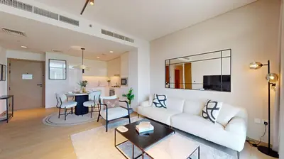 a living room with a white couch and a table at Palace Residence - Chic Two Bed with Creek View in Dubai