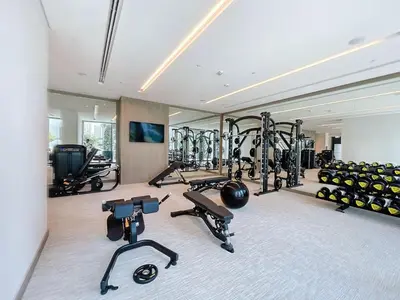 a gym with several treadmills and exercise bikes at Palace Residence - Chic Two Bed with Creek View in Dubai